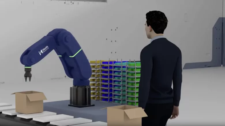 Image of person watching robotic arm in action.