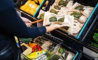 Person grabbing Sainsbury’s avocados at the grocery store.