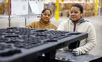 Image of ORBIS employees handling pallets