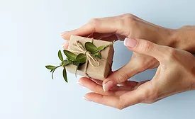 Image of hands holding what is suggested to be sustainable packaging