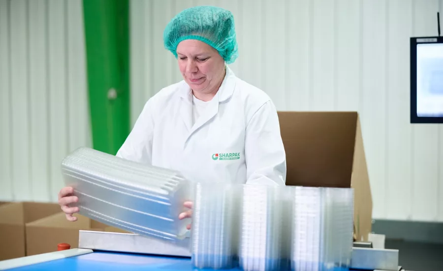 SHARPAK trays being stacked by a worker