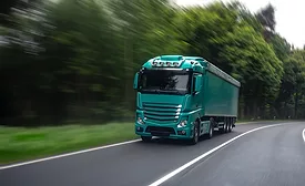 Long-haul freight truck driving through forest