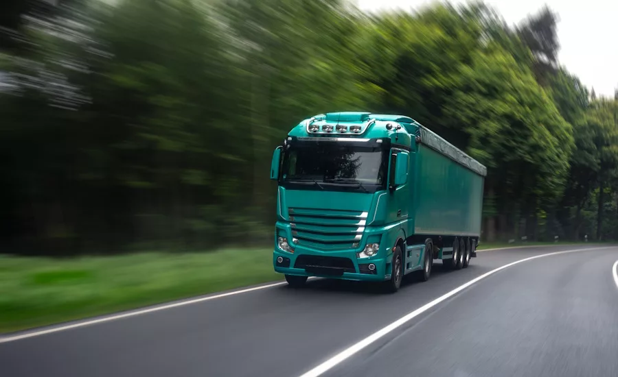 Long-haul freight truck driving through forest