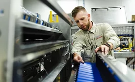 Technician reviews the cross conveyor on a Newtec weigher inside the Fox Solutions facility.