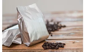Image of flexible coffee bag surrounded by coffee beans