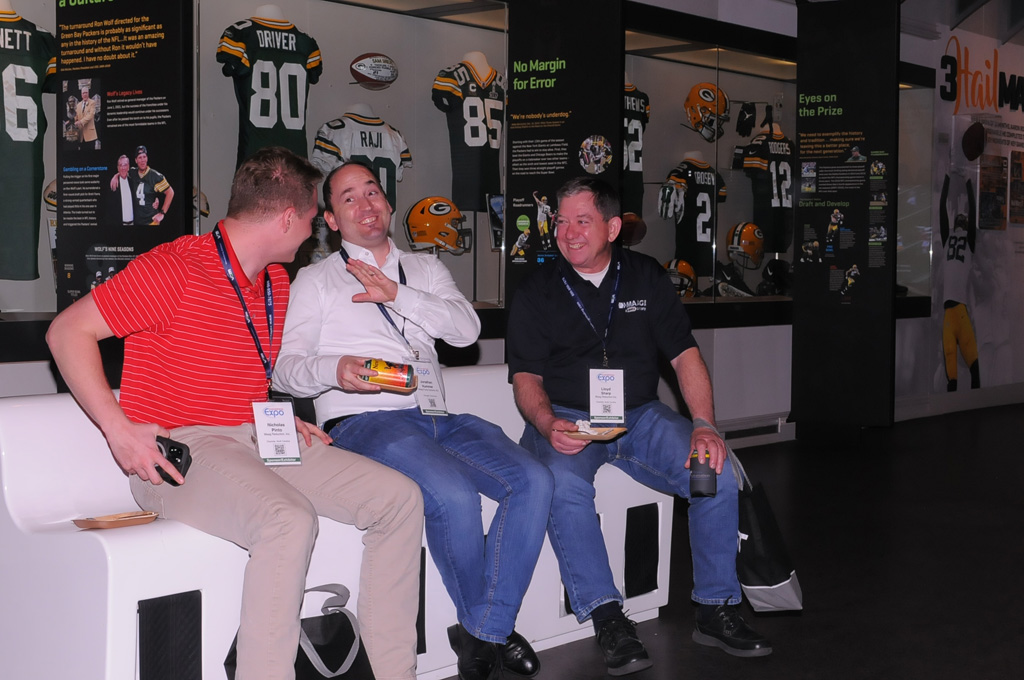 A group of 3 men in front of a display at Lambeau Field