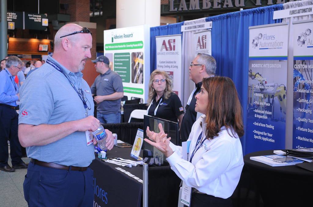Adiscussion at a Converters Expo exhibit booth