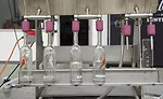 Valentine Distilling bottles are placed by hand on the 6-head semi-automatic filler
