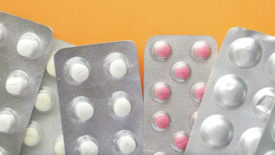 Close up of pills of blister pack orange background