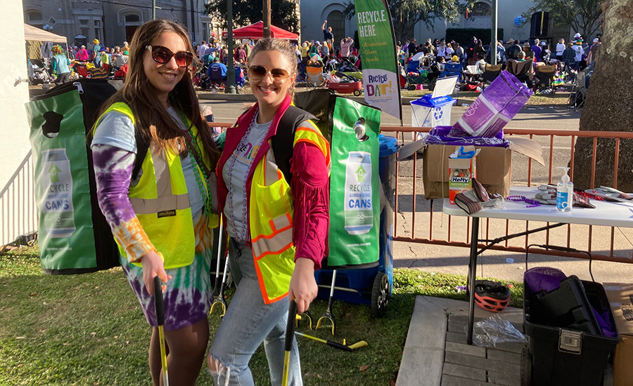 Two volunteers wearing specially designed backpacks to collect used aluminum beverage cans during Mardi Gras