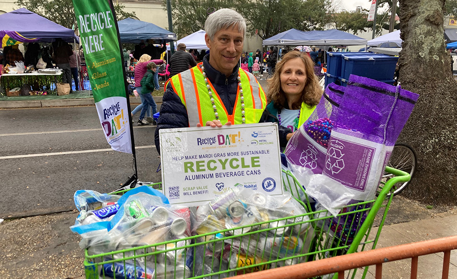 Two volunteers with empty cans they collected from Mardi Gras parade-goers