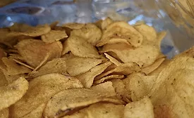 Hand taking chips out of a package