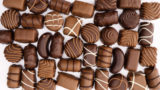 PS February 2024 Candy Confectionary feature image of variety of chocolates on marble background.