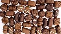 PS February 2024 Candy Confectionary feature image of variety of chocolates on marble background.