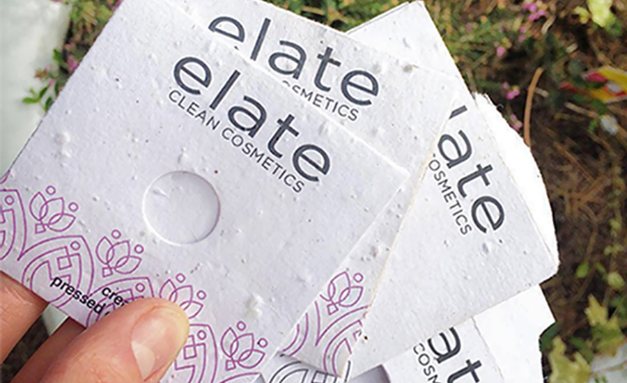 Elate Clean Cosmetics packaging with a flower bed in the background.