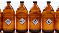 Warning symbols for chemical hazards on chemical containers.