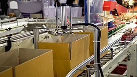 Automatic cardboard box packing and tape sealing machine.