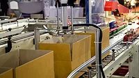 Automatic cardboard box packing and tape sealing machine.
