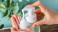 Hand pumping soap into other hand.