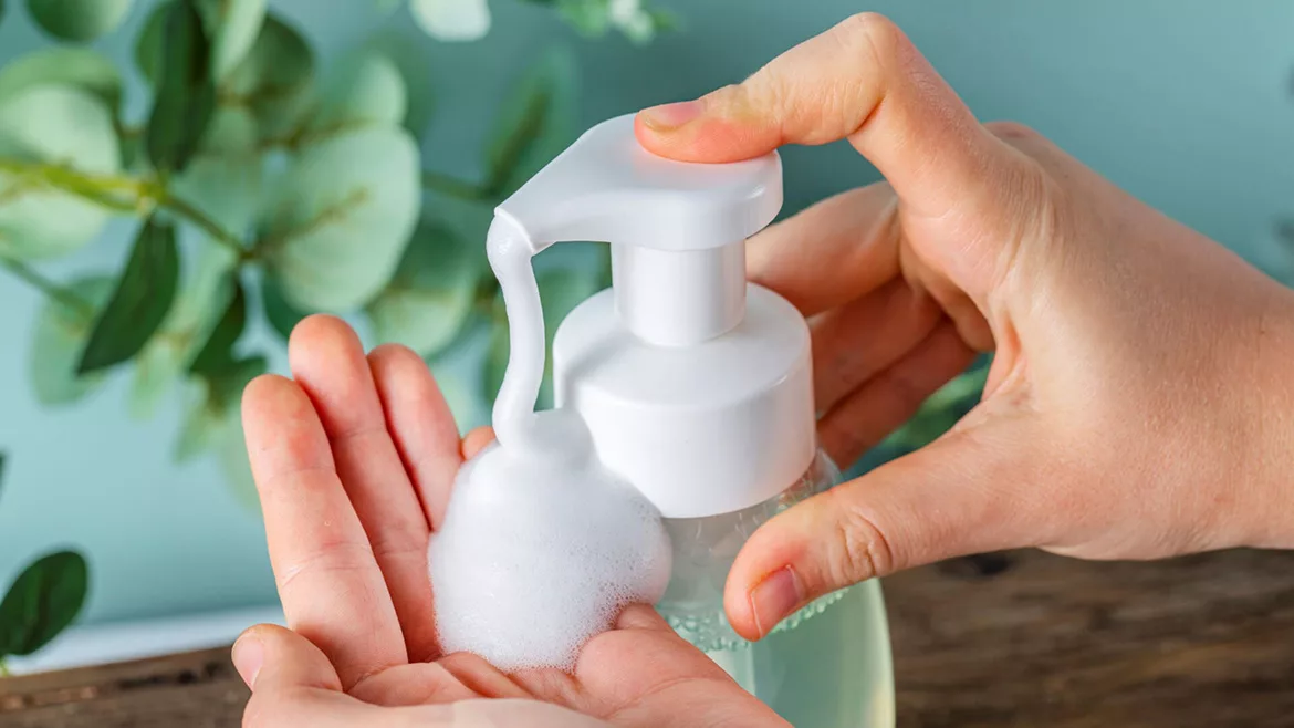 Hand pumping soap into other hand.