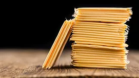 Packaged cheese (sliced) on an old wooden table as a detailed close-up shot.