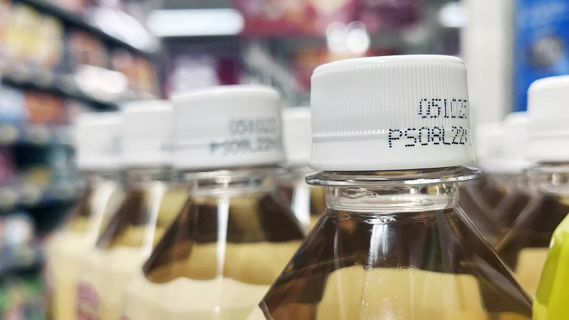 Close-up of bottles of drinks in a supermarket.