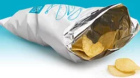 Potato chips in an opened TIPA package against a white background.