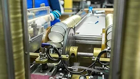 Image of beverage cans being assembled in a packaging facility.