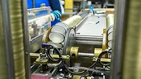 Image of beverage cans being assembled in a packaging facility.
