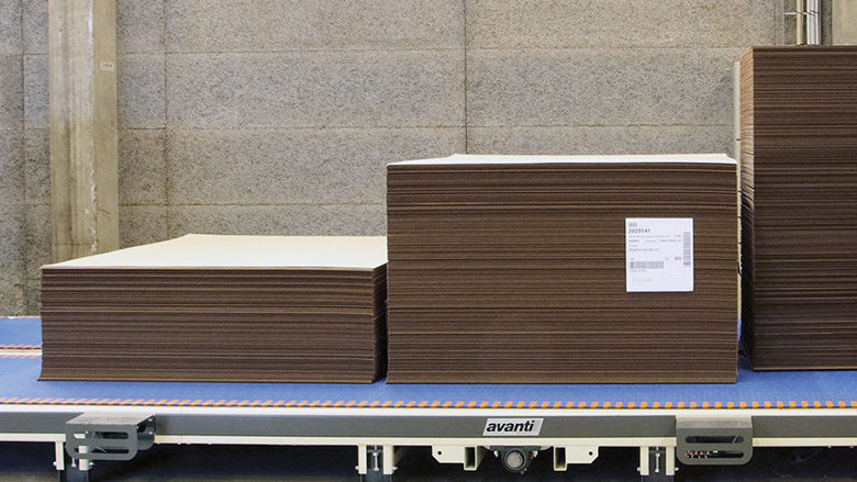 Image of stacks of corrugated cardboard on a conveyor belt.