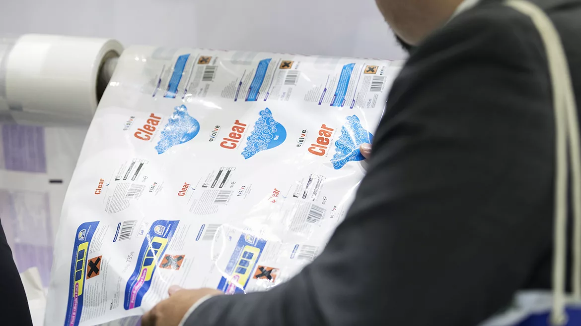 Conference attendee inspecting a roll of digitally printed labels.