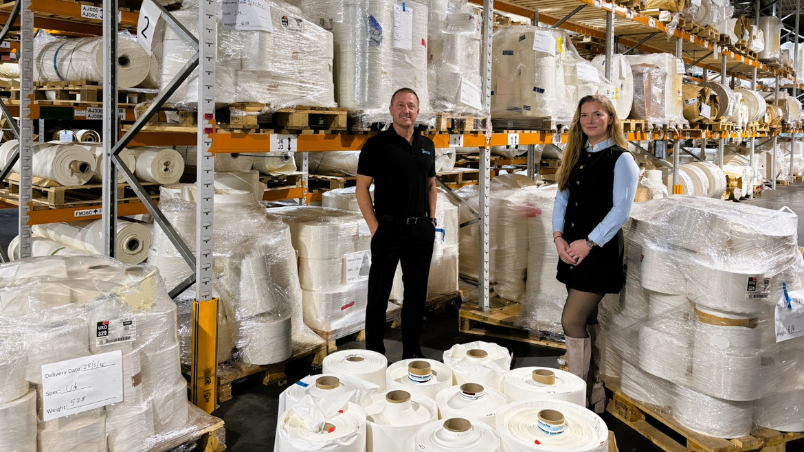 Mark Thompson and Marci Clarke with rolls of labels in warehouse.