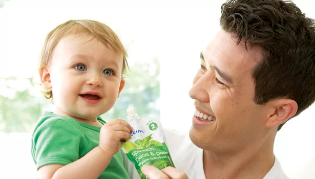 father feeding baby plum pouches food bananas pears mangos
