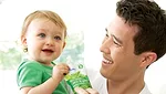 father feeding baby plum pouches food bananas pears mangos
