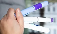 Hand Holding Various Semaglutide and Insulin Injection Pens for different stages of the treatment.